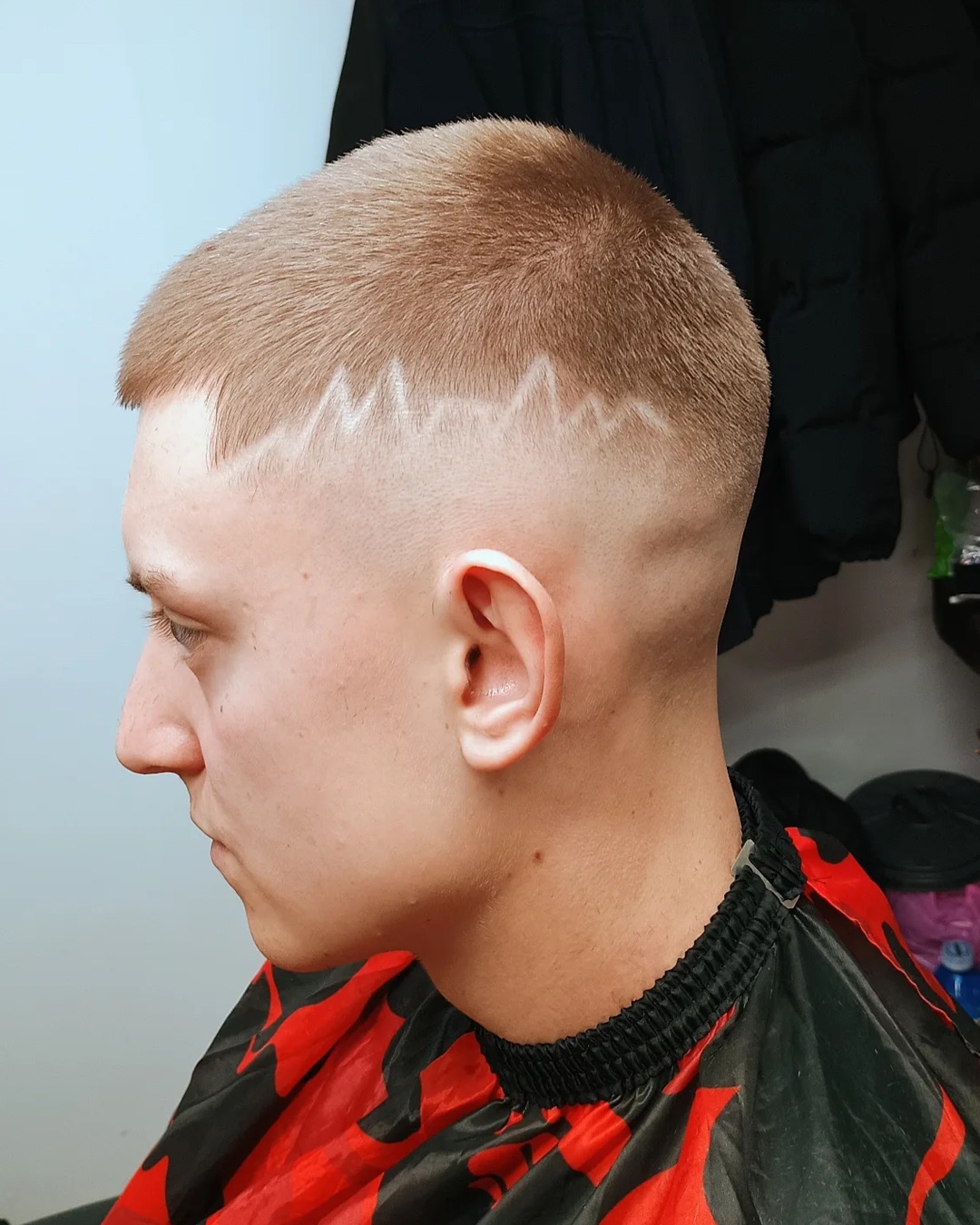 blonde buzz cut with high skin fade featuring a heartbeat radio wave hair design