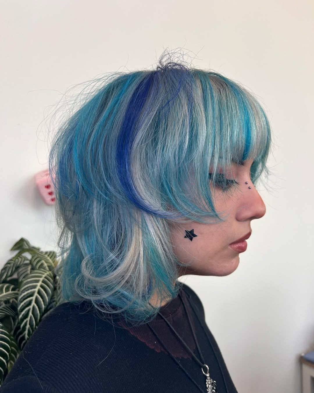woman with choppy shag cut and multi shade blue highlights