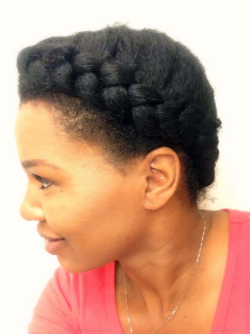 Chunky French braid curving along the side of the head into a tucked updo.