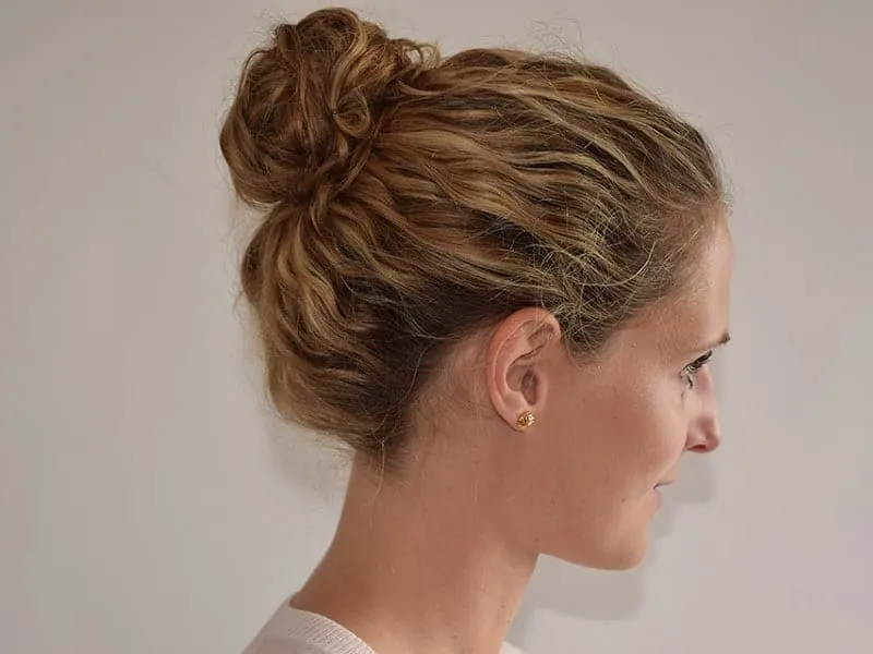 curly brown hair bun with blonde highlights