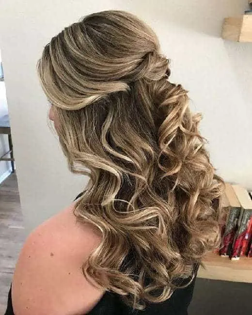 curly light brown hairstyle with blonde highlights