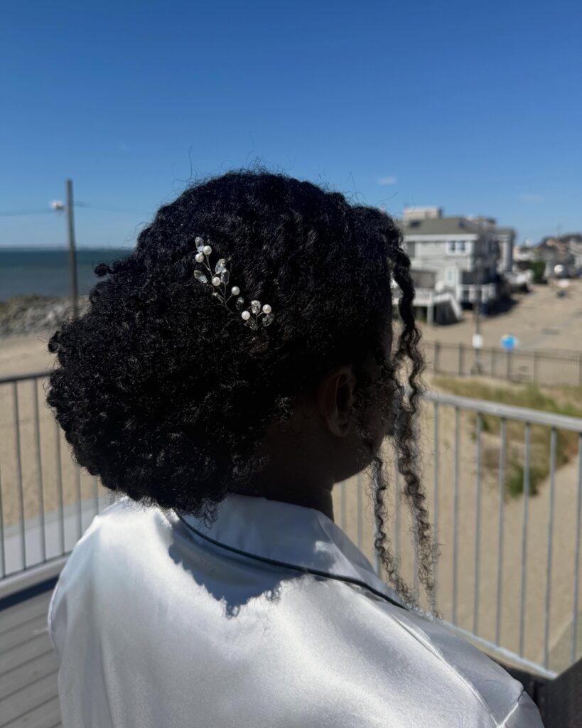 curly low chignon bun with pearl clip for black brides