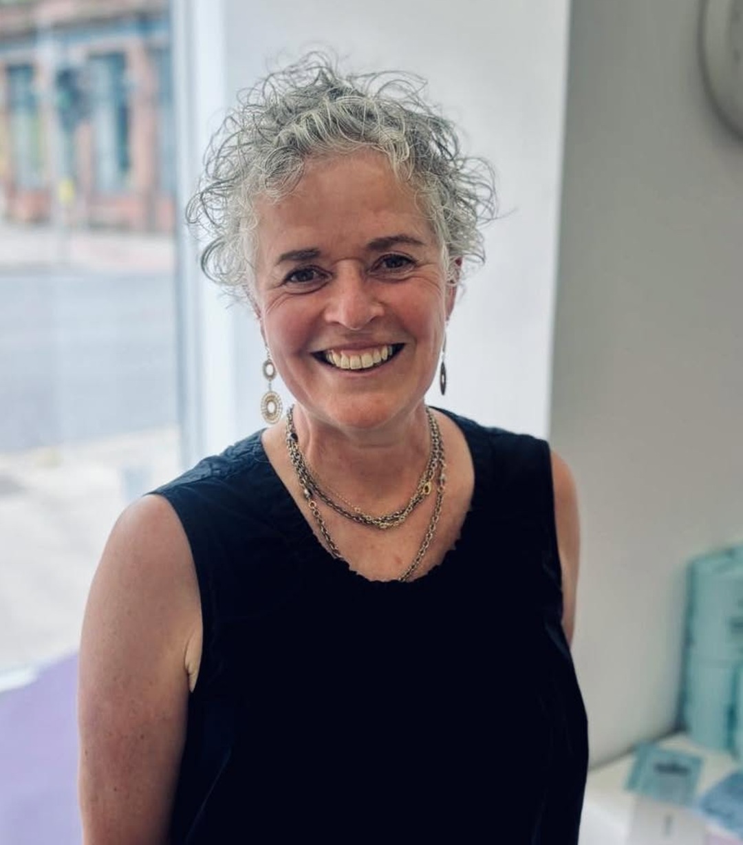 older woman over 60 with a short messy curly gray crop haircut for fine hair