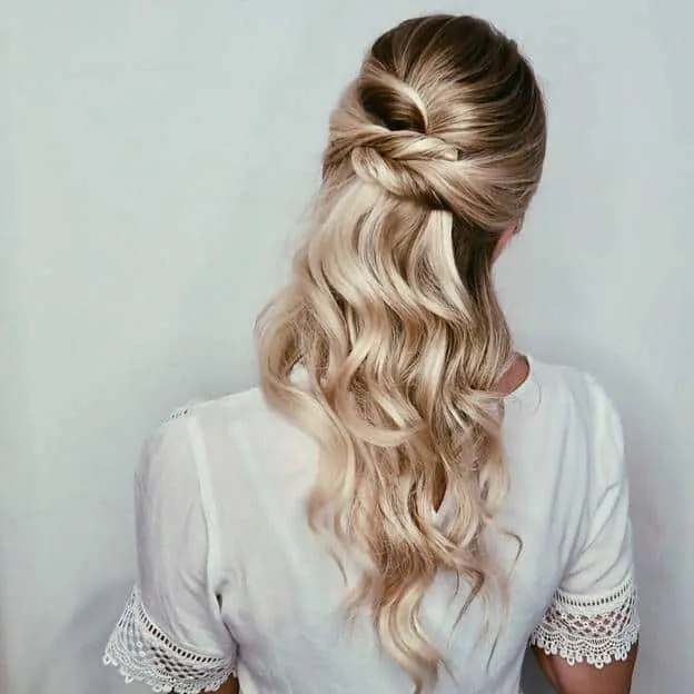 knotted half-up style with curly frizzy hair