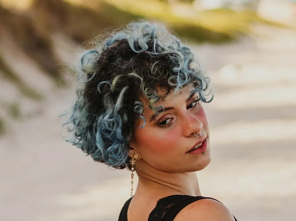 curly hair with pastel blue highlights