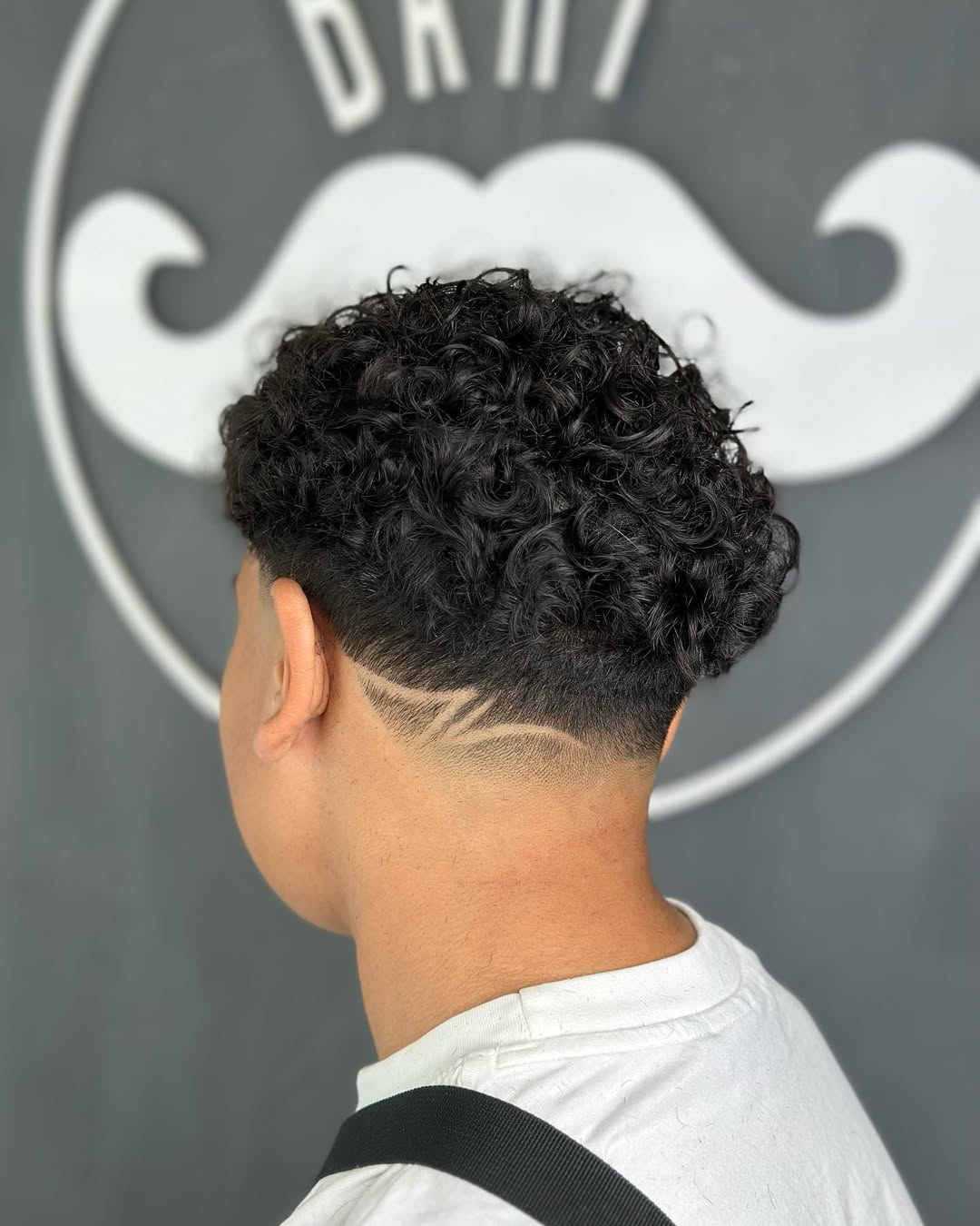 curly crop haircut with low taper fade and shaved neck line design