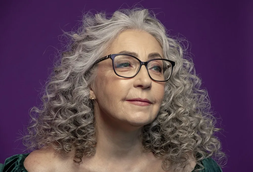 Curly layered hairstyle for people over 50 with glasses