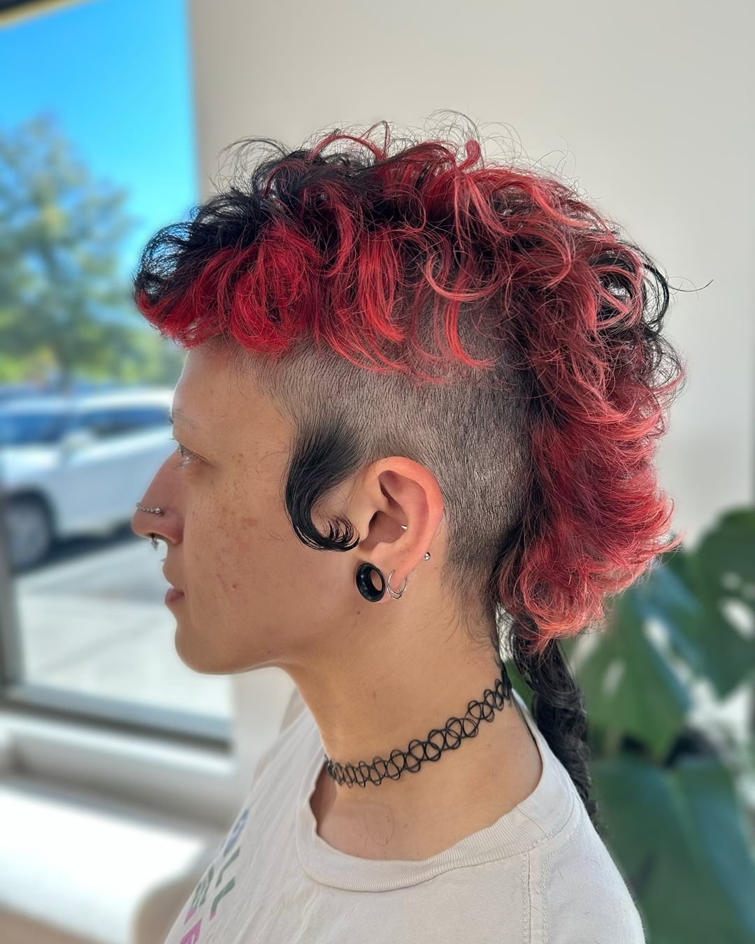 Woman with a curly red mohawk rockabilly haircut featuring shaved sides