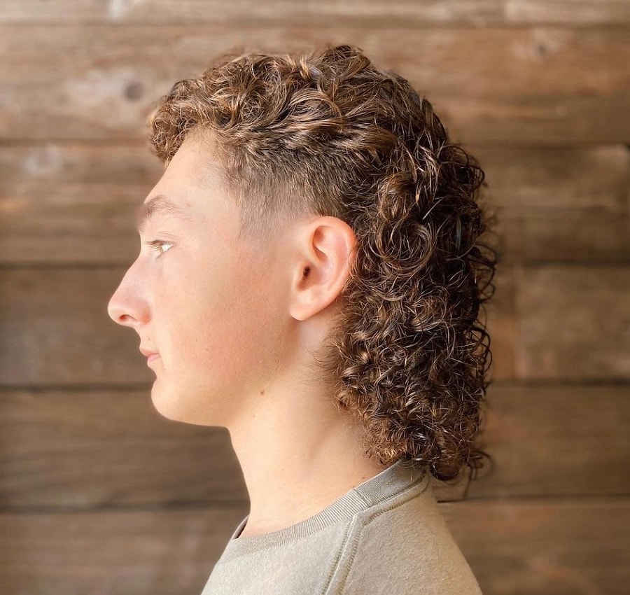 A curly mullet fades to a round face