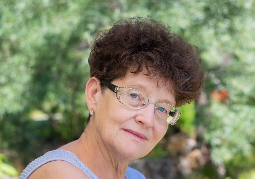Curly pixie cut for older women with glasses