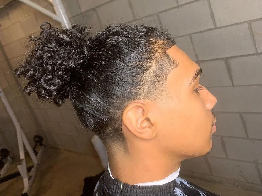curly ponytail with low taper fade