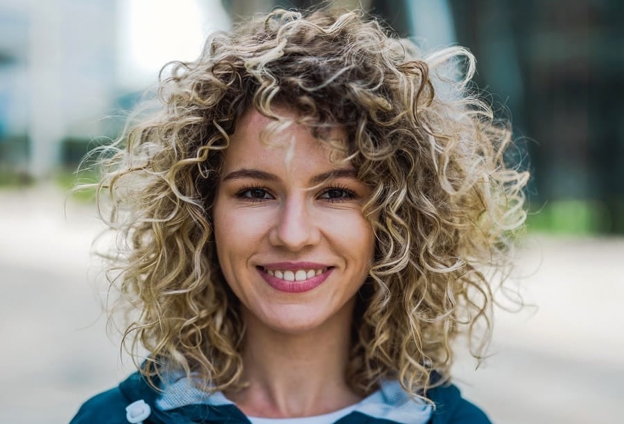 shoulder-length curly shag with blonde highlights and voluminous layers