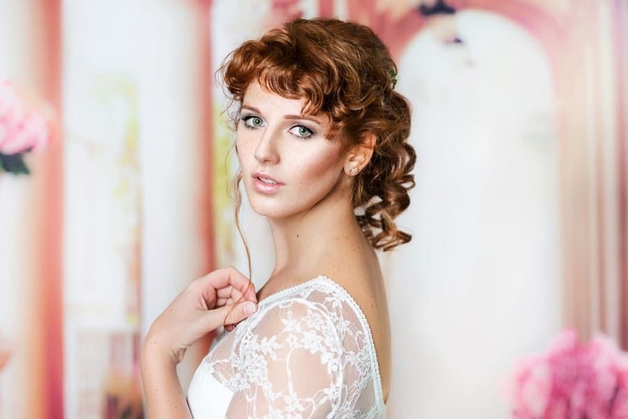 Portrait of a beautiful smiling bride in white wedding dress young woman  with long curly hair style and makeup sitting on  CanStock