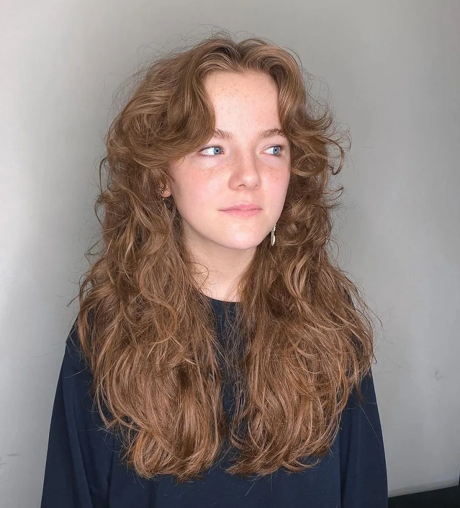 curly wolf haircut with curtain bangs