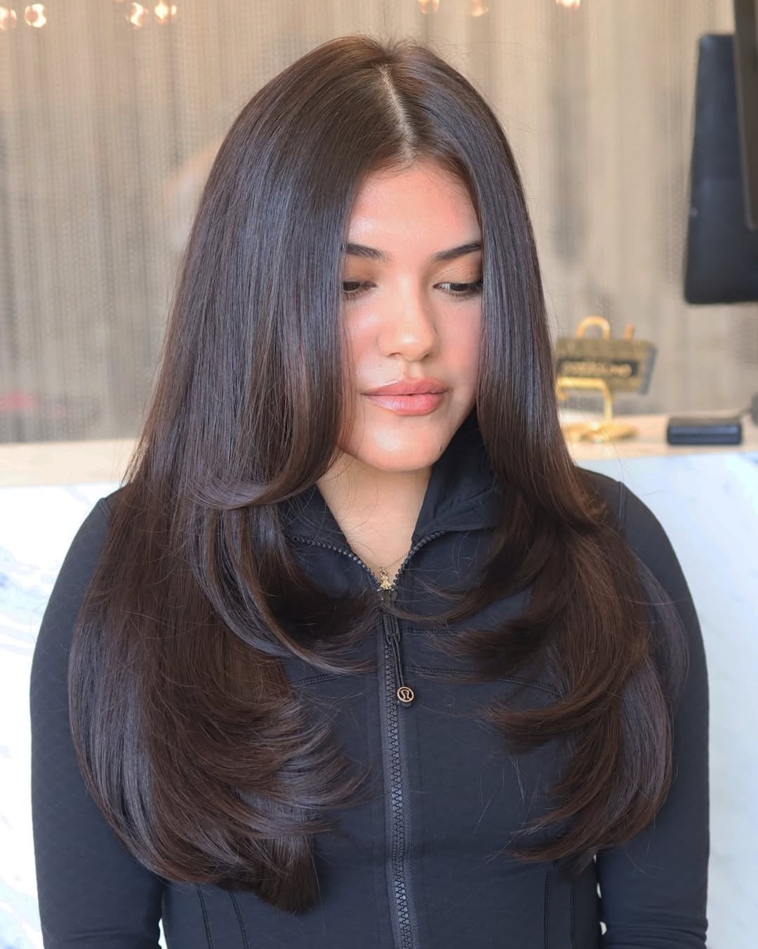 dark brown hair styled with long face-framing layers and smooth blowout