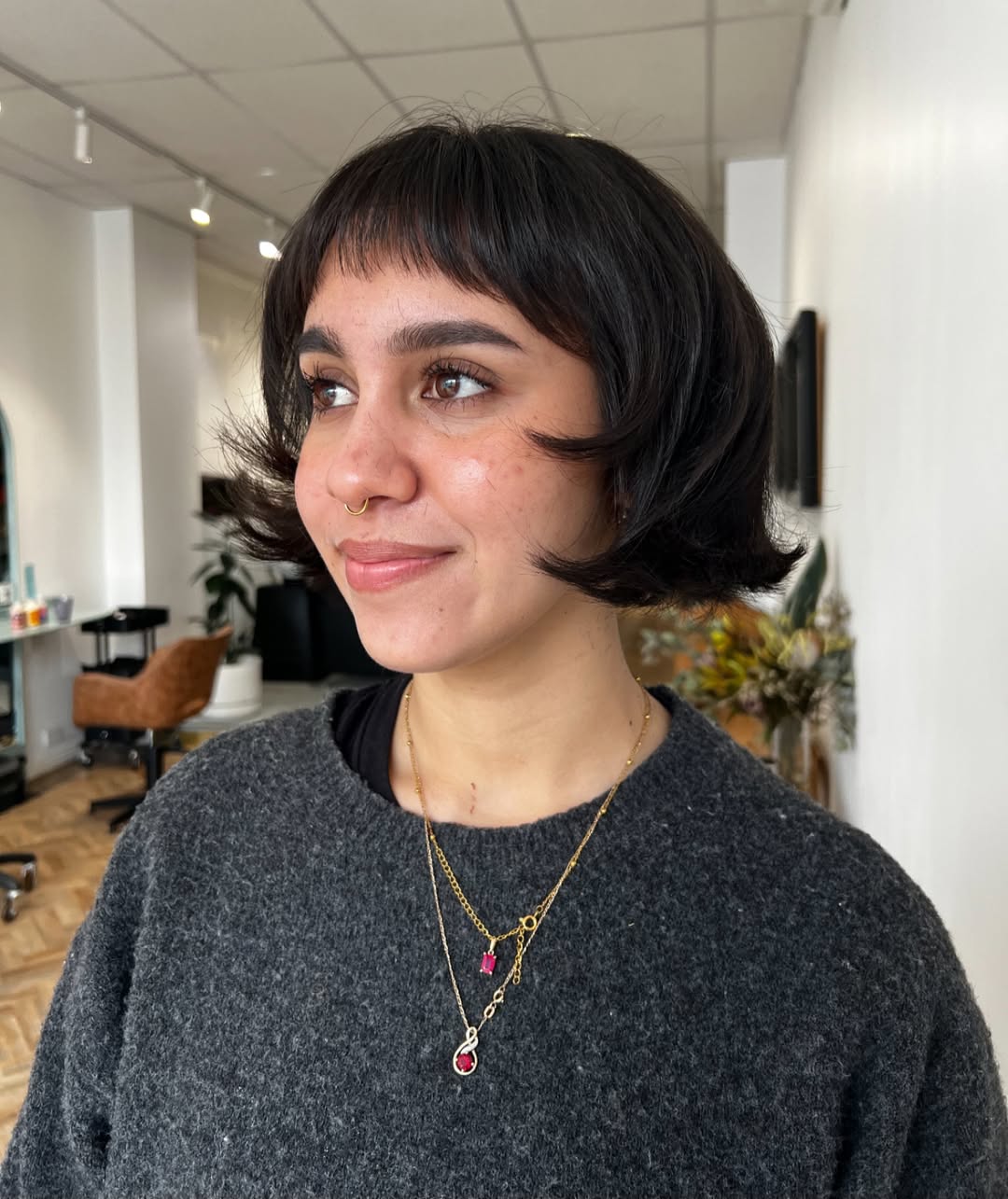 Brunette woman with a flared Dutch boy style bob and soft wispy fringe