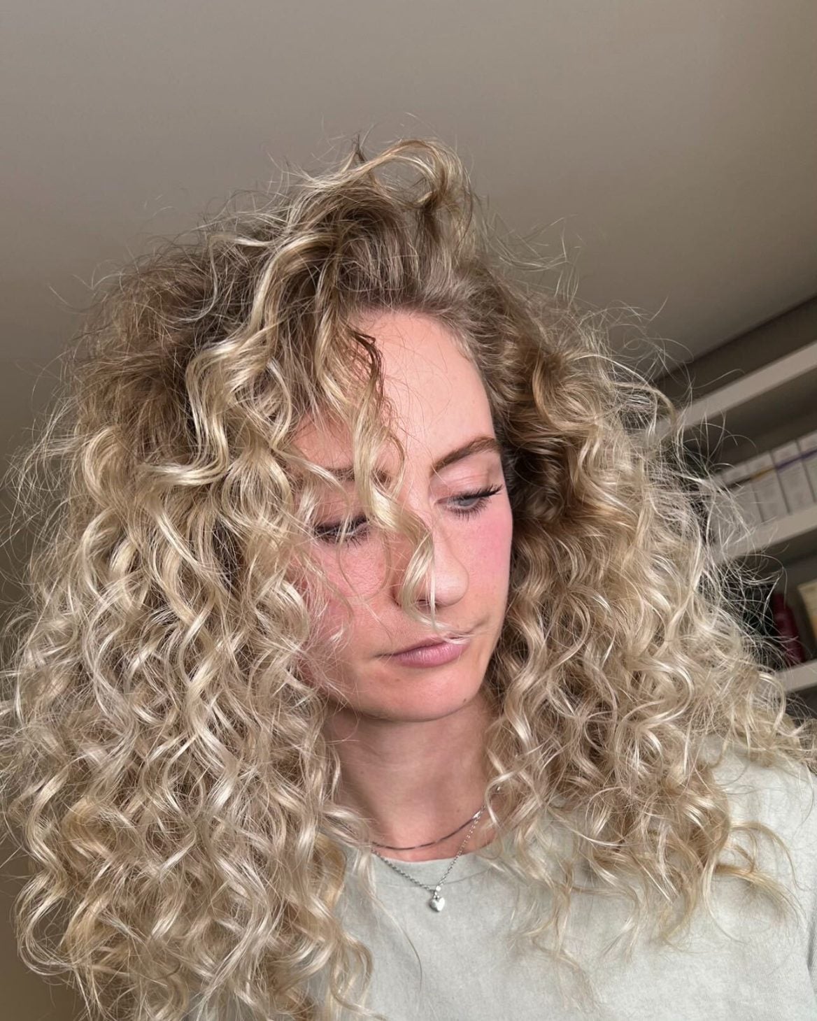 Client with blonde hair in defined natural curls framing the face