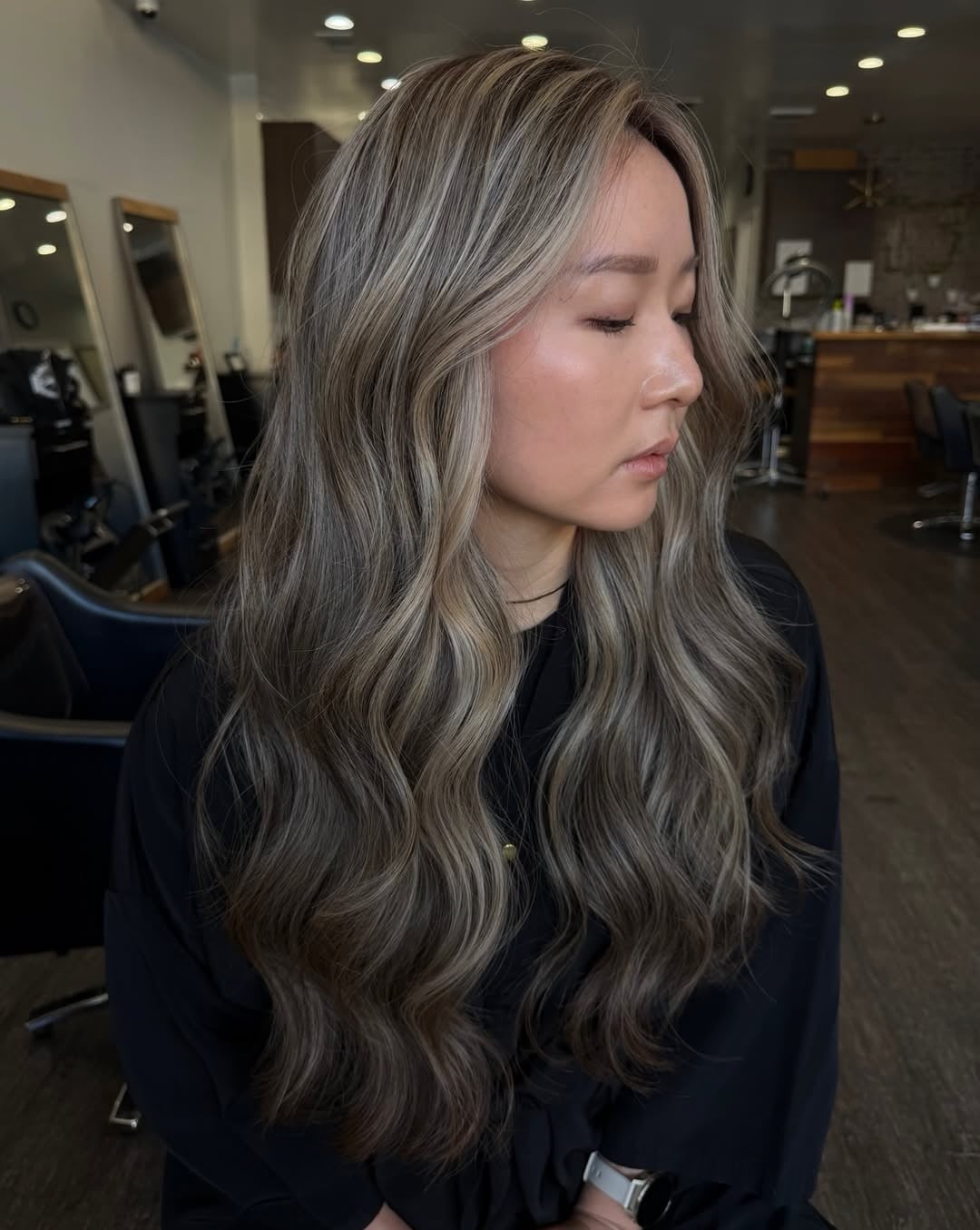 Asian woman with long wavy dimensional ash beige blonde hair