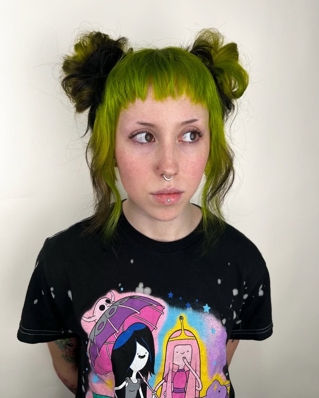 neon green and black double bun updo with blunt micro bangs