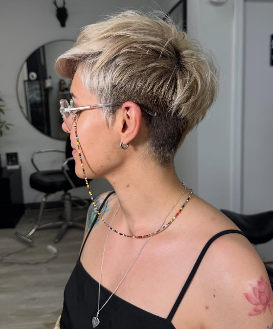 blonde female undercut haircut with dark roots and textured highlights