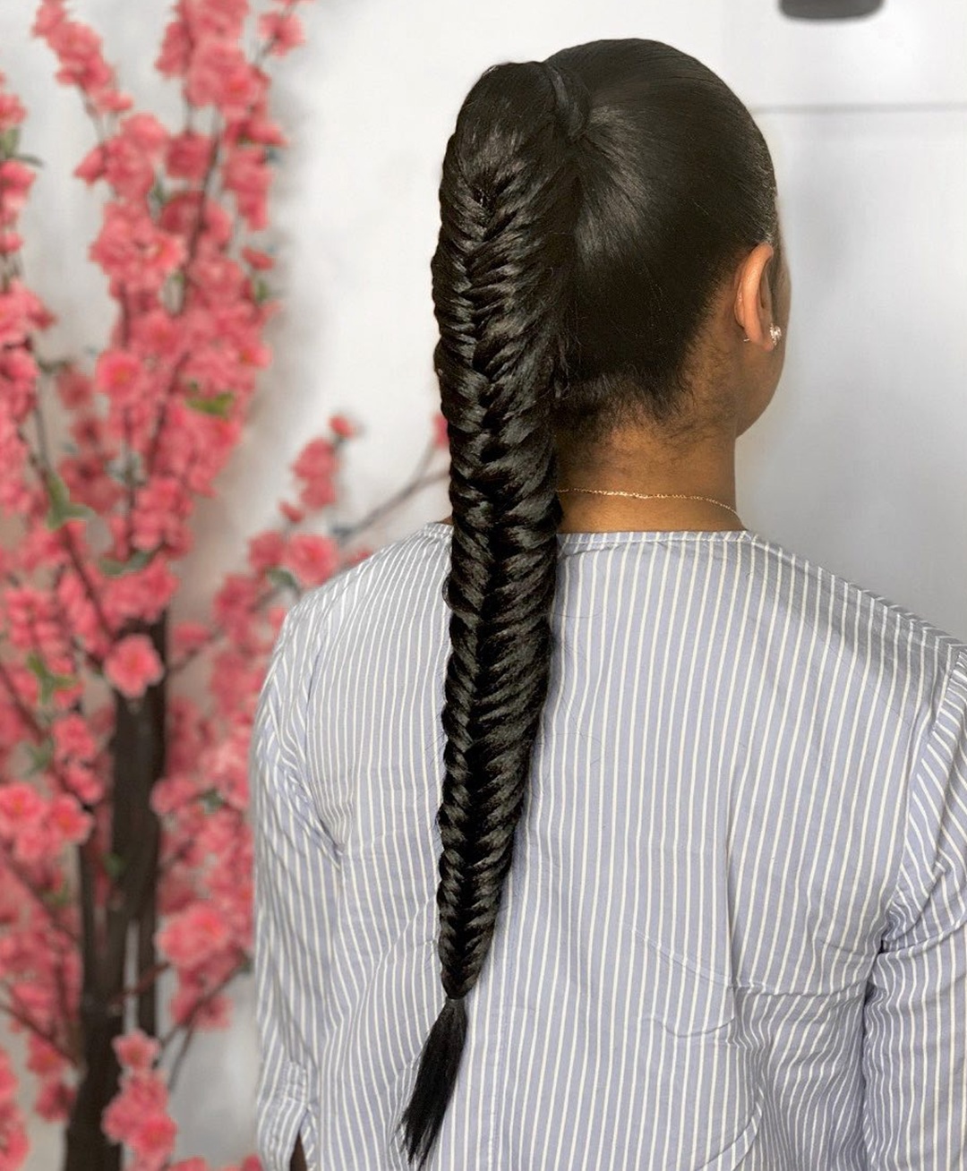 Back view of a long invisible fishtail braided ponytail slicked smooth at the crown