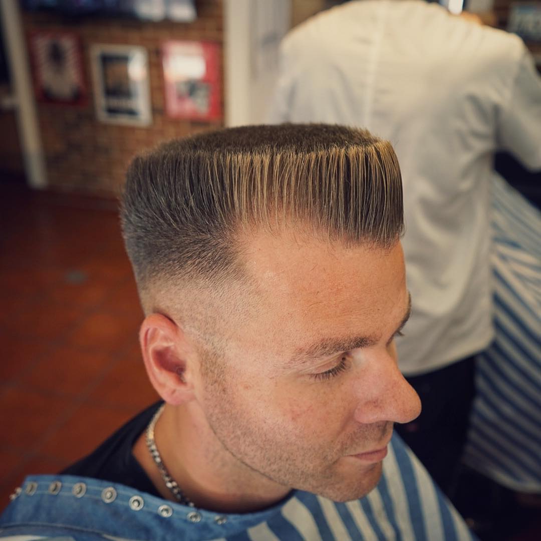 Flat top haircut with high skin fade and blonde highlights