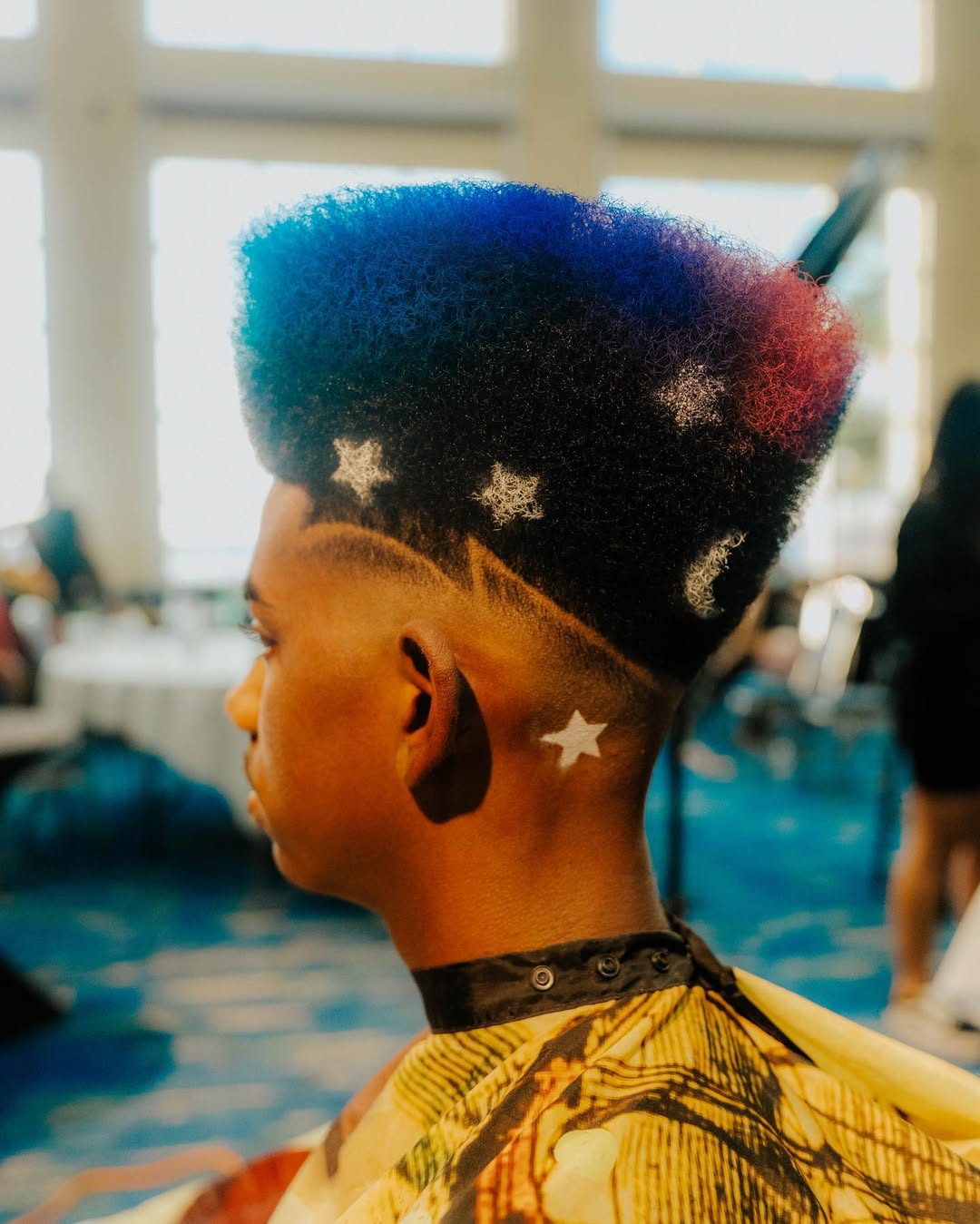 Colorful afro flat top haircut with star designs and tri-color dye