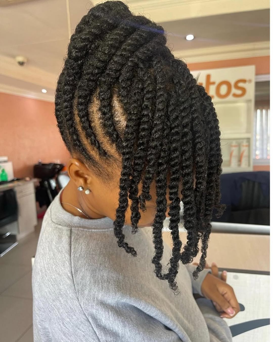 Flat twist updo with long two-strand twist bangs cascading forward