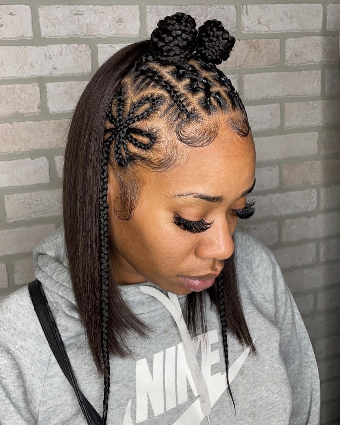 straight dark bob hairstyle featuring a braided flower side design and mini space buns on top
