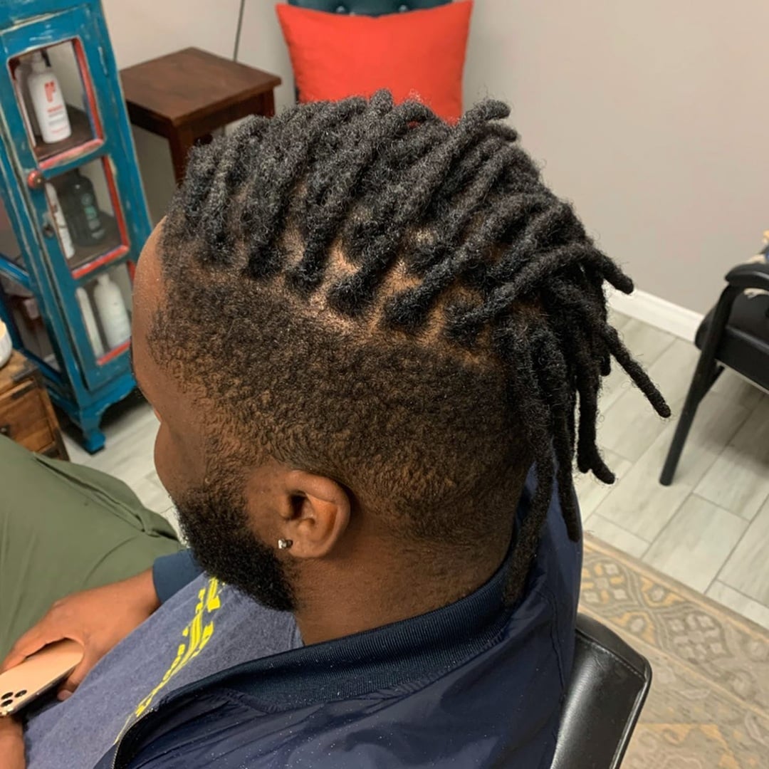 Black man with top freeform dreadlocks and a side undercut