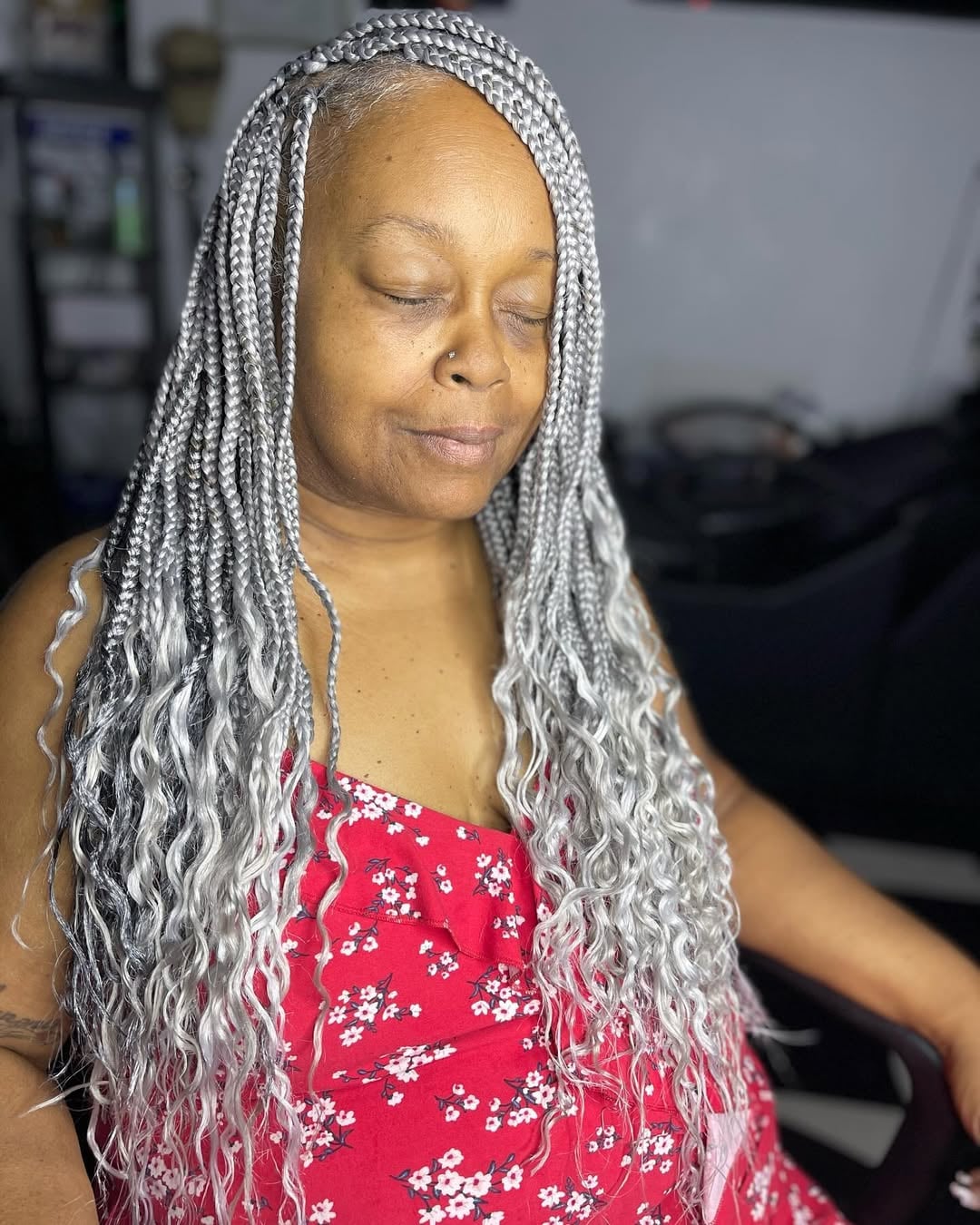 Older black woman with long silver-gray braids and loose, curly ends