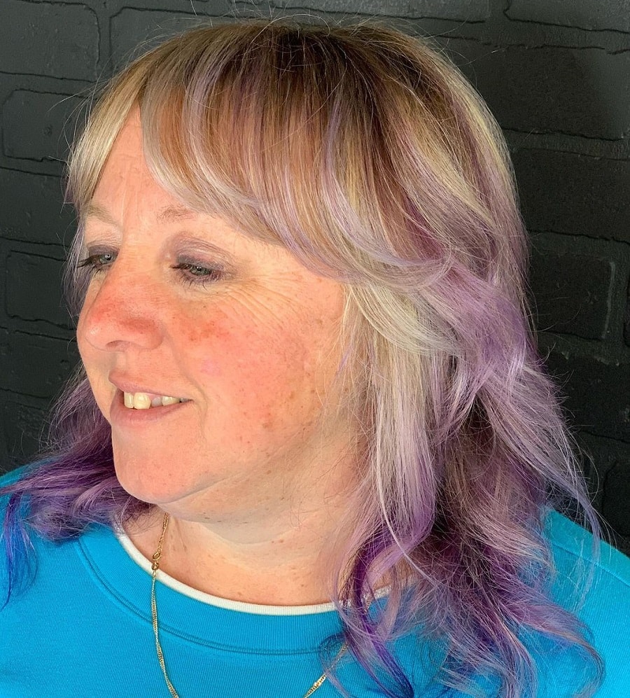 gray hair with purple highlights and curtain bangs