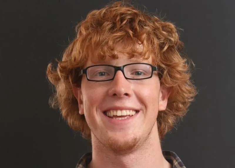 Portrait of young man with red hair against orange background stock photo