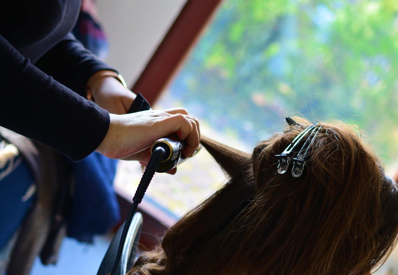 hairdresser working using hair straightener