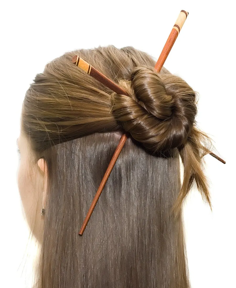 half bun hairstyle with hair stick