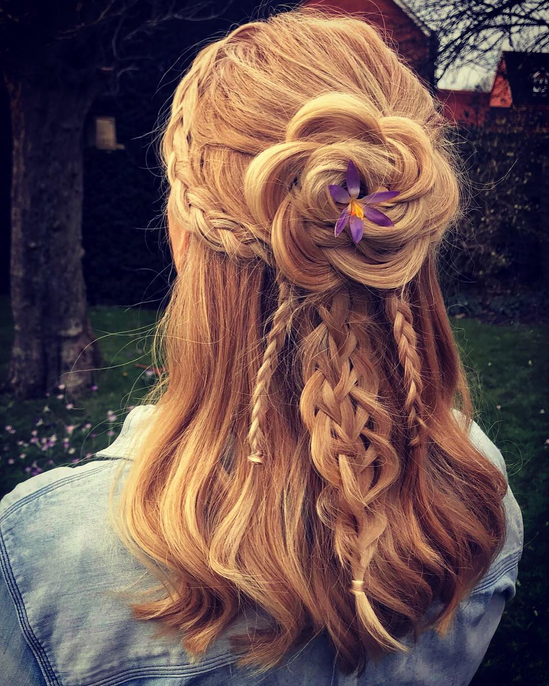 half up Viking braid hairstyle with hair rose and flower accent