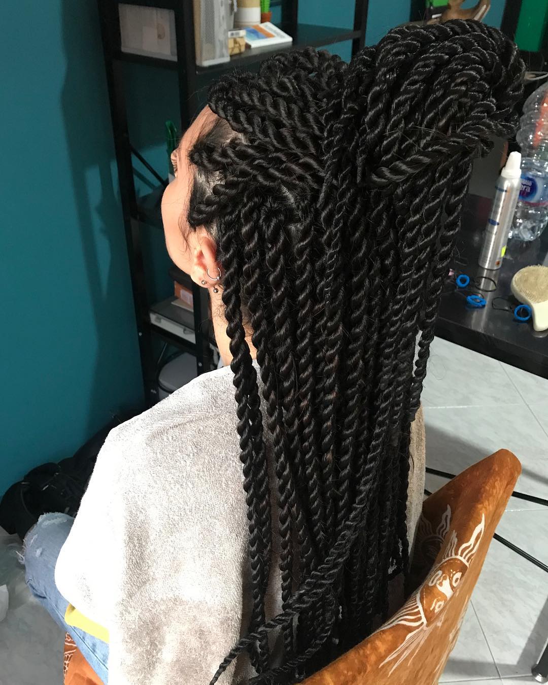 Long black rope twist braids extensions gathered in a high half-up top knot