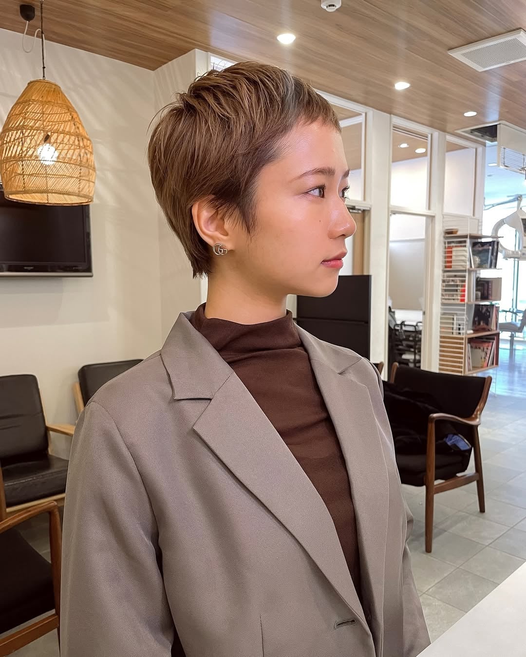 Asian woman with a honey brown pixie cut and micro bangs