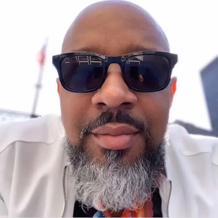 A black bald guy with a salt and pepper beard