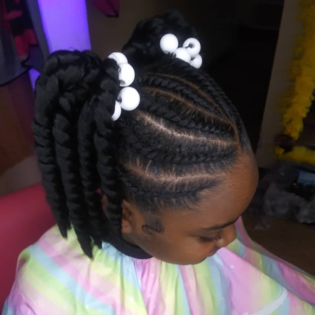 Little black girl with double high jumbo twist pigtails secured with white ball hair ties