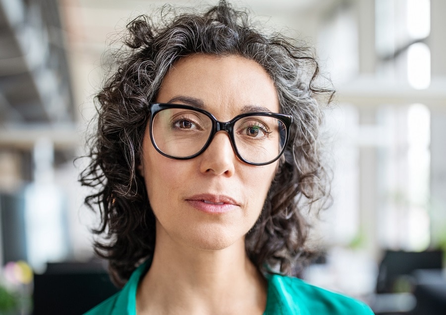 layered curly bob for women over 50 with glasses