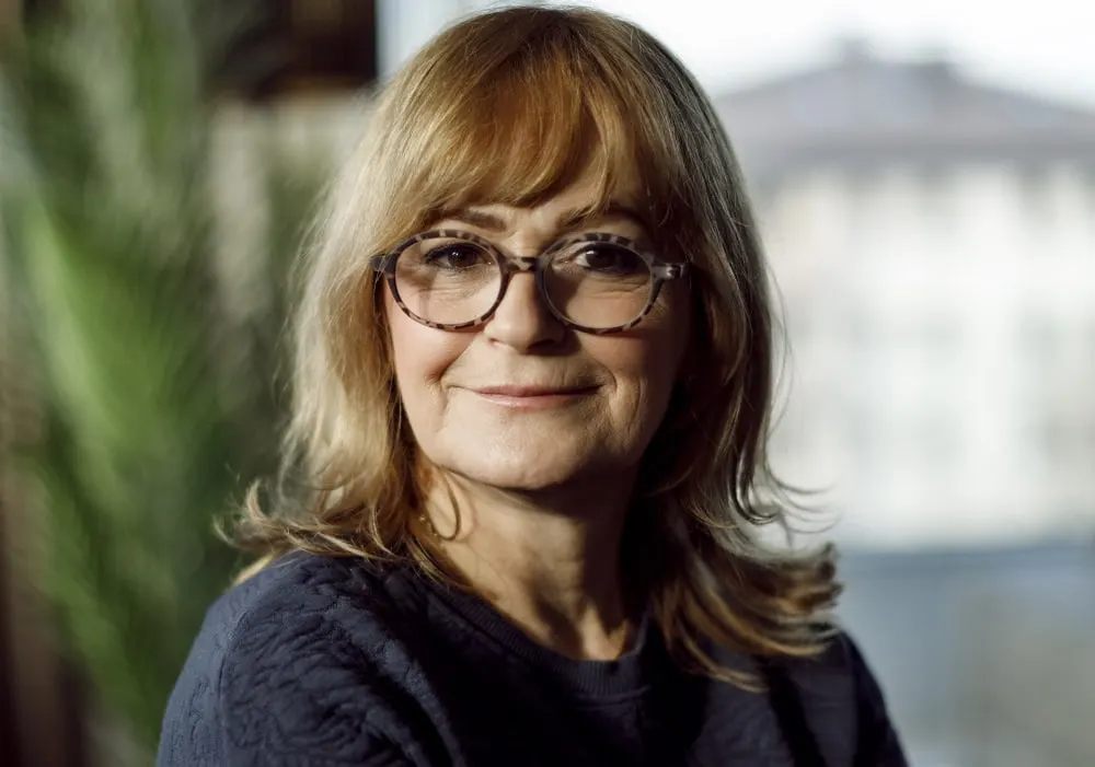 layered hairstyle for over 50 with glasses and bangs