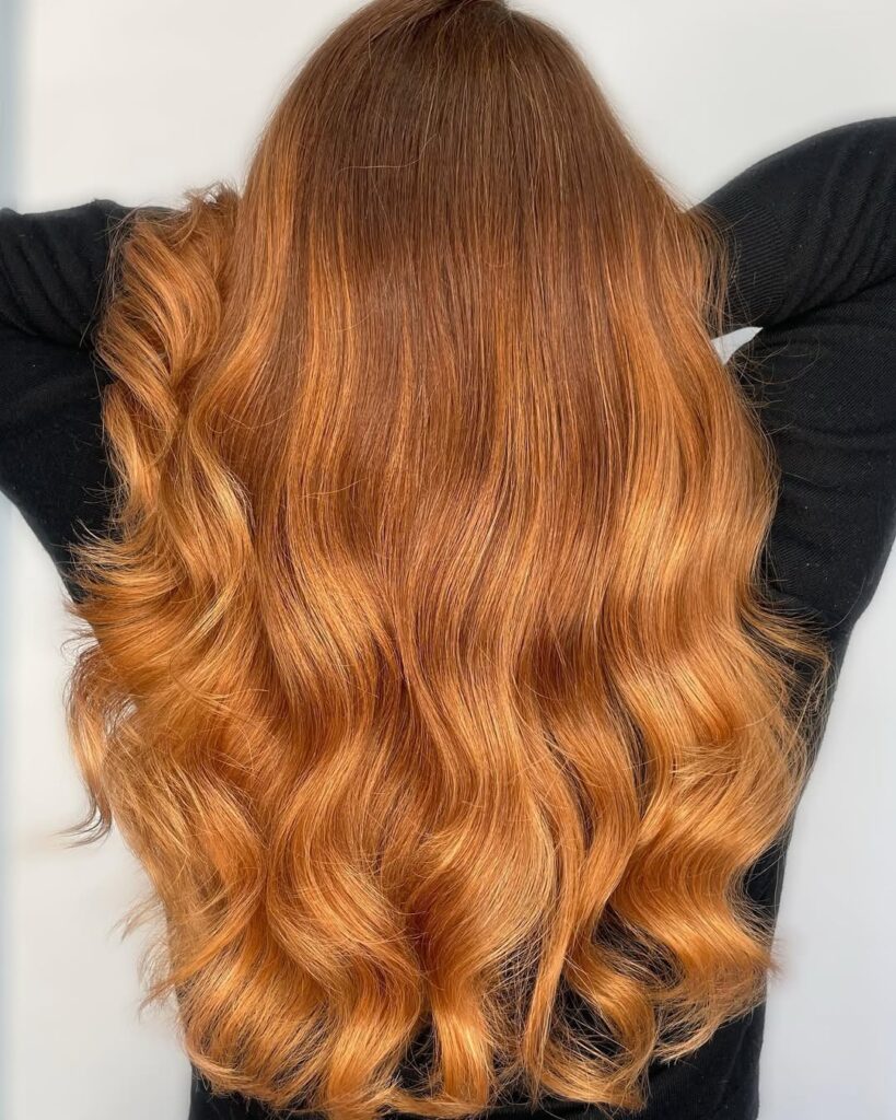 warm light auburn blended into golden blonde long waves