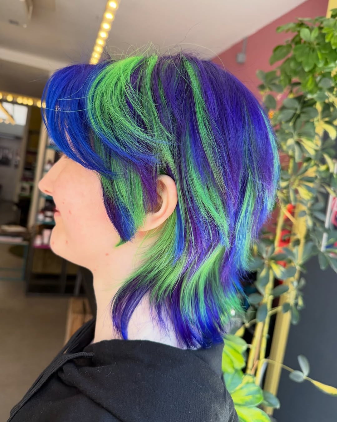 Textured shag mullet in vibrant cobalt blue and lime green hair colors