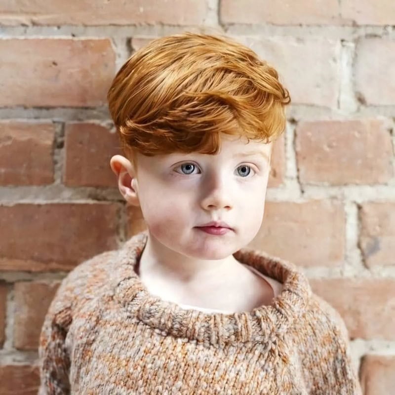 little boy with straight ginger hair styled with  side-swept and heavy fringe