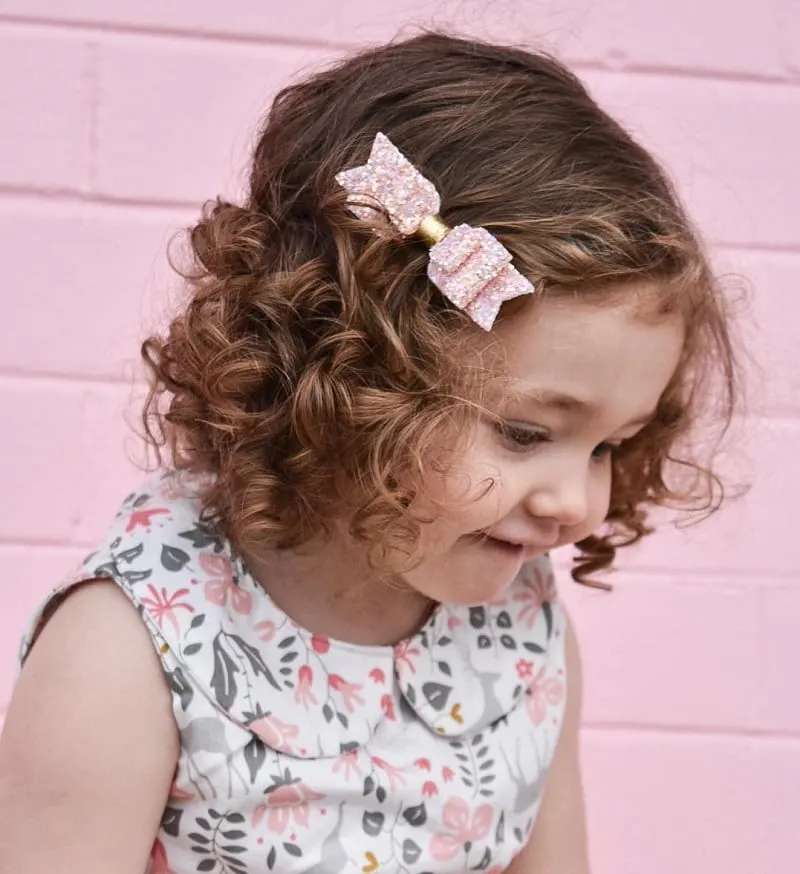 little girl's short curls with bow