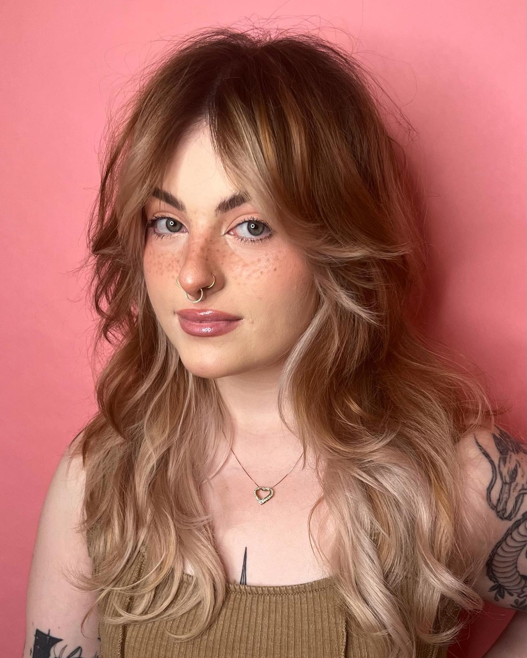 long blonde shag haircut with voluminous curtain bangs and soft outward-curled layers