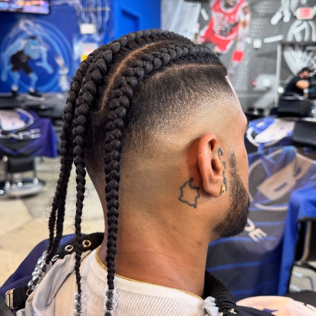 long cornrow braids and a high skin fade