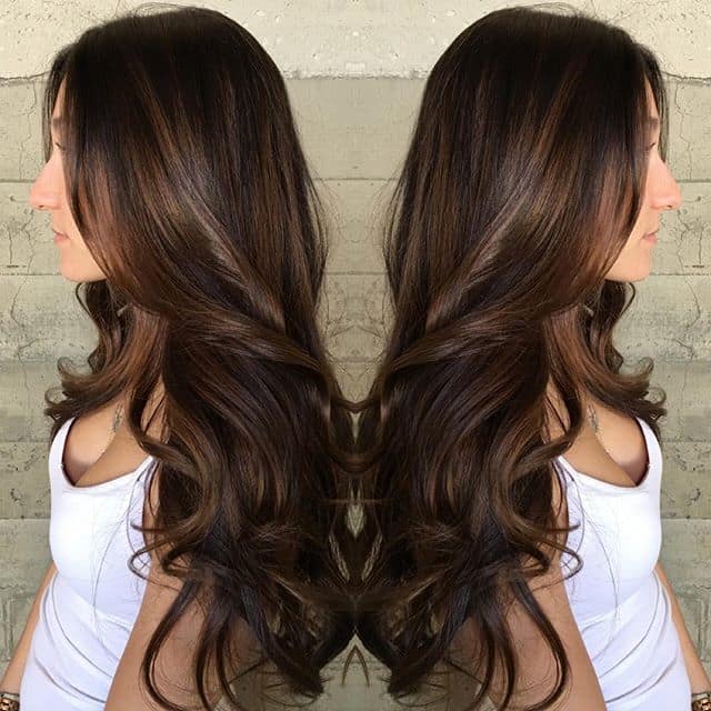 Side view of long chocolate brown hair styled in rich, flowing loose waves