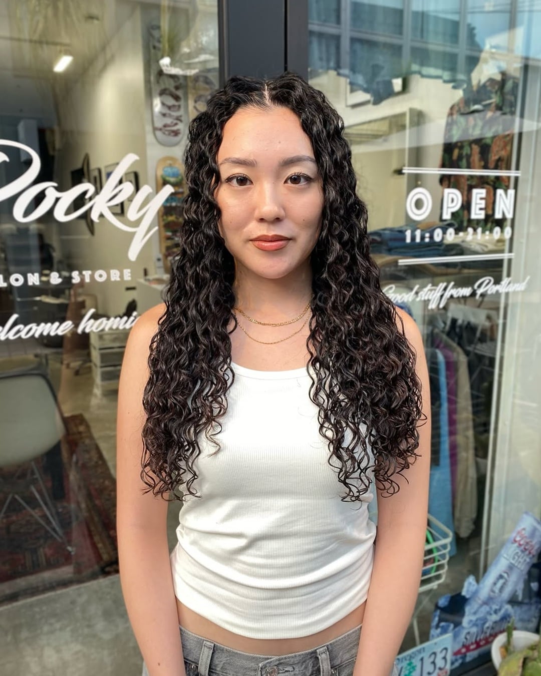 long dark perm hair with defined tight spiral curls and middle part